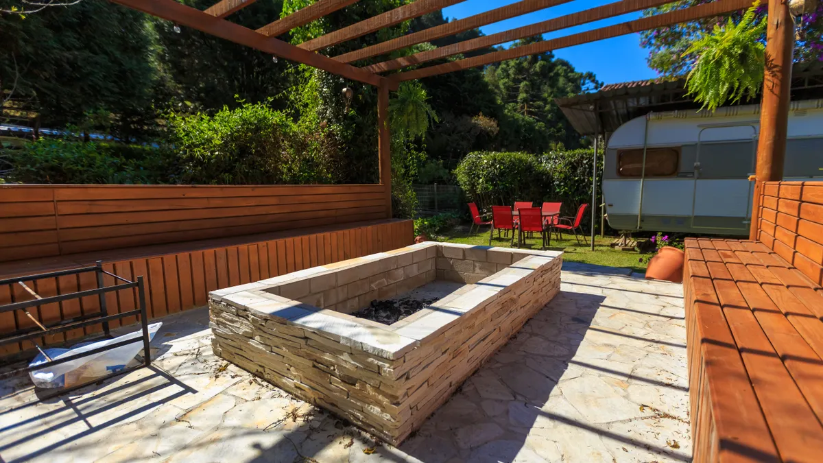 How to Design a Stamped Concrete Patio for Fire Pits Rectangular fire pit on paved patio with wooden bench seating