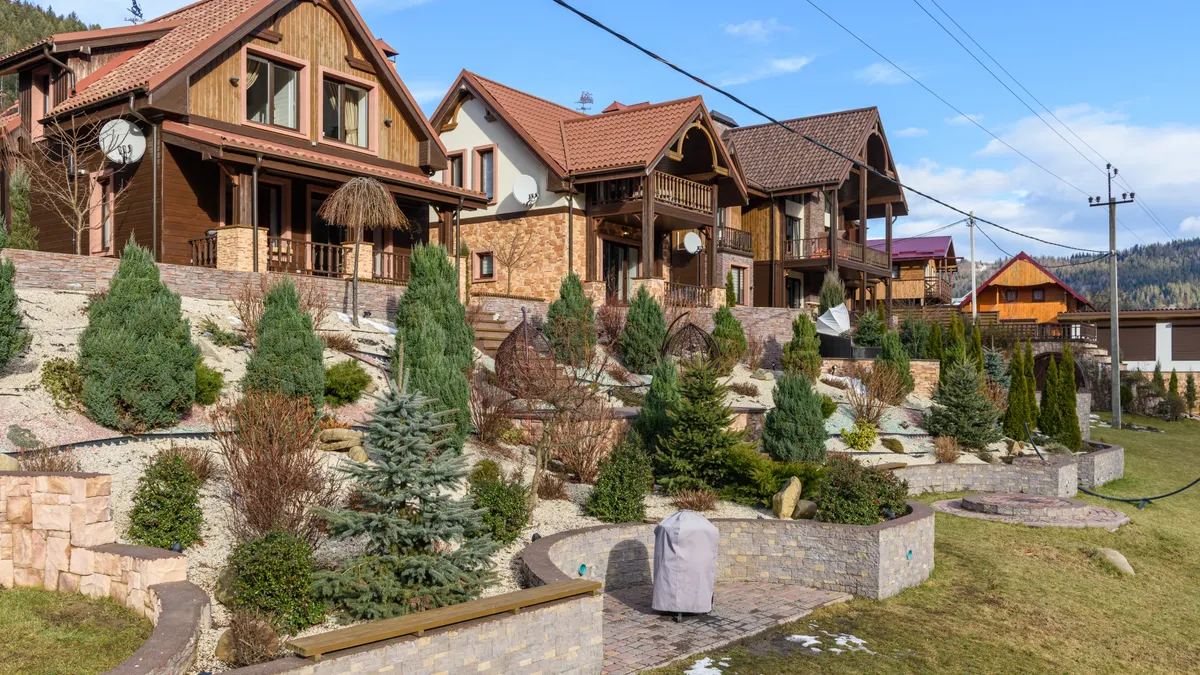 Stamped Concrete Patio Design Ideas for Sloped Backyards Terraced hillside homes with retaining walls and planted slopes