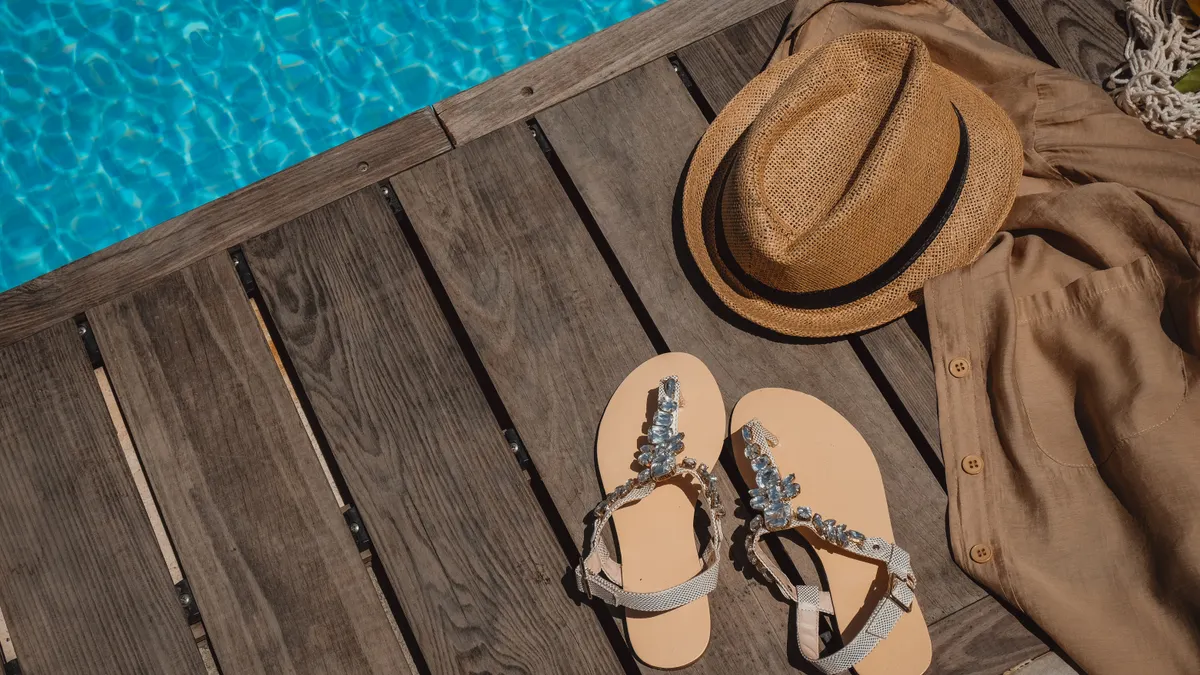 Stamped Concrete Patio Designs for Pool Areas Poolside wooden deck with sandals and hat