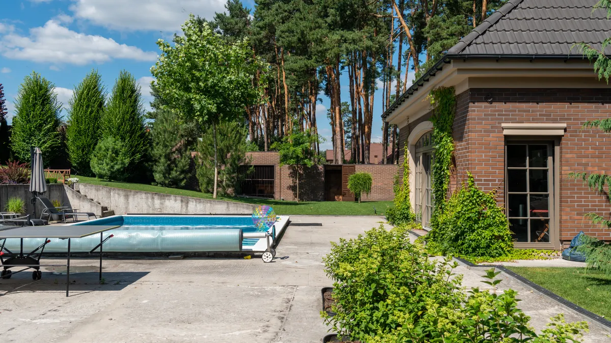 Backyard pool area with patio and house